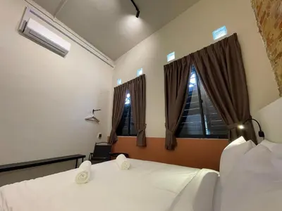 a bedroom with two beds and a window at Miner's House Ipoh in Ipoh