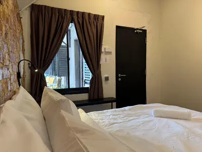 a bedroom with a white bed and a window at Miner's House Ipoh in Ipoh