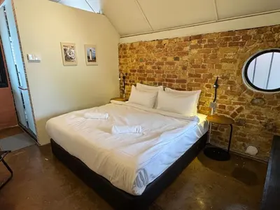 a bed in a room with a brick wall at Miner's House Ipoh in Ipoh