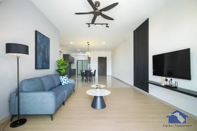 a living room with a blue couch and a ceiling fan at Sunshine Residence Suites in Ayer Itam