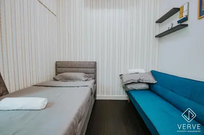 a room with two beds and a blue couch at Ipoh Residence PR1MA Kepayang 6 pax suites in Ipoh