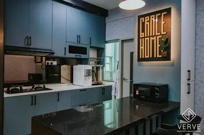 a kitchen with blue cabinets and a black counter top at Ipoh Residence PR1MA Kepayang 6 pax suites in Ipoh
