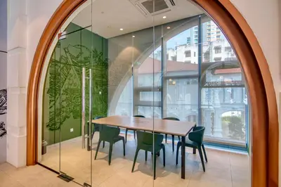a dining room with a table and chairs and a window at 22 Macalisterz Premium Suites Penang by BYON in George Town