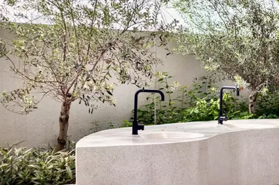 a white table with a sink in front of a tree at 22 Macalisterz Premium Suites Penang by BYON in George Town