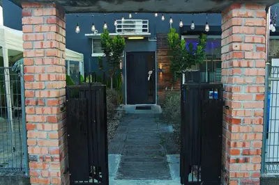 a house with a black door and a brick wall at The Nook Holiday Home Cozy, Stylish, Swimming Pool in Ipoh
