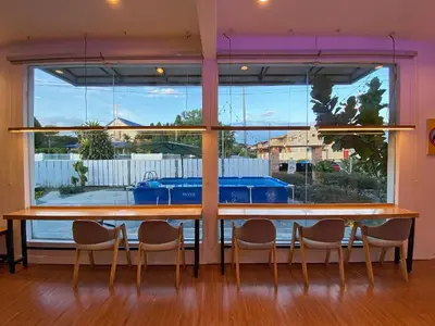 a table with chairs in front of a large window at The Nook Holiday Home Cozy, Stylish, Swimming Pool in Ipoh