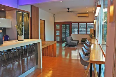a kitchen and living room with a bar and chairs at The Nook Holiday Home Cozy, Stylish, Swimming Pool in Ipoh