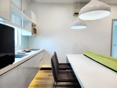 a kitchen with a white counter and a table with a chair at The Tiny Treasure Stay #1BR in George Town