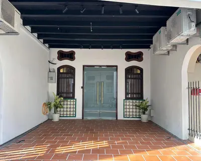 a building with a blue door and a brick floor at Toh Aka Inn in George Town