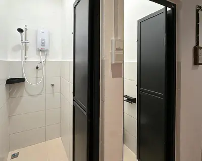 a bathroom with a black door and a shower at Toh Aka Inn in George Town