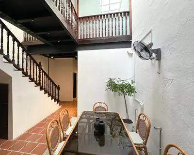 a dining room with a table and chairs and stairs at Toh Aka Inn in George Town