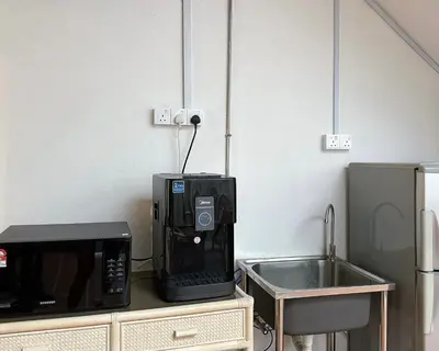 a kitchen with a microwave and a sink at Toh Aka Inn in George Town