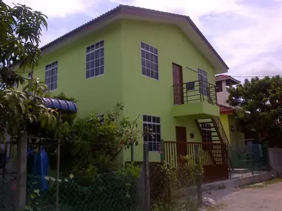 a green house with a fence in front of it at Penang Green Homestay in Permatang Pauh