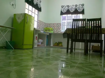 a kitchen with a table and a green refrigerator at Penang Green Homestay in Permatang Pauh