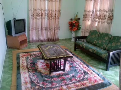a living room with a couch and a table at Penang Green Homestay in Permatang Pauh