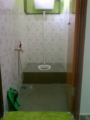 a small bathroom with a toilet in a stall at Penang Green Homestay in Permatang Pauh