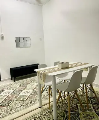 a dining room with a white table and chairs at Homestay Bonda F in TanjongMalim
