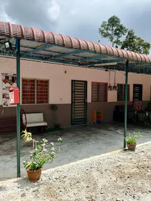 a building with a patio with plants in front of it at Homestay Bait Al-Sakinah in Simpang Ampat