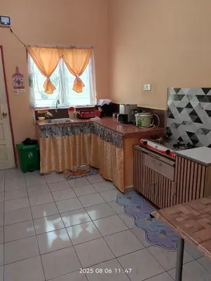 a kitchen with a counter and a window in it at Homestay Bait Al-Sakinah in Simpang Ampat