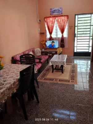 a living room with a couch and a table at Homestay Bait Al-Sakinah in Simpang Ampat