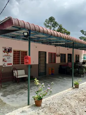 a building with awning and plants in front of it at Homestay Bait Al-Sakinah in Simpang Ampat