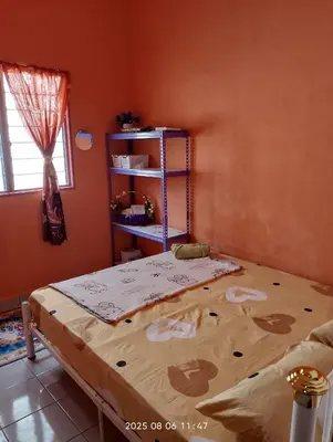 a bedroom with a bed and a book shelf at Homestay Bait Al-Sakinah in Simpang Ampat