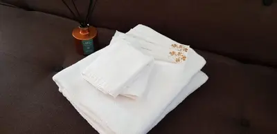 a pile of white towels sitting on a couch at The Haven Resort 3 rooms renovated suite in Tambun