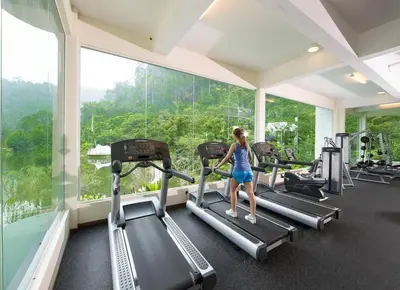 a woman walking on treadmills in a gym at The Haven Resort 3 rooms renovated suite in Tambun