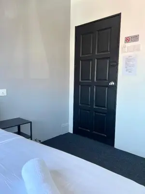 a bedroom with a black door and a bed at Quee Hotel in George Town