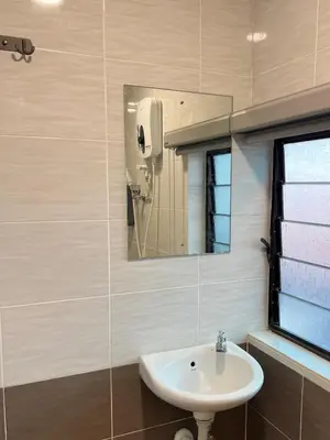 a bathroom with a sink and a mirror at Quee Hotel in George Town