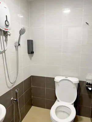 a bathroom with a shower with a toilet and a sink at Quee Hotel in George Town