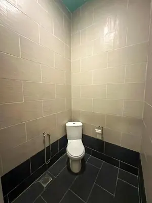 a bathroom with a white toilet in a stall at Cabin in the Valley in Tambun