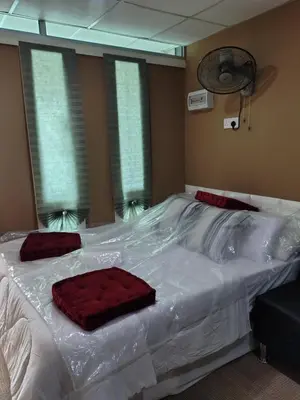 a bed covered in plastic with two red pillows on it at QALSHARYNA CHALET inn in Taiping