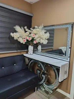 a mirror and a table with flowers on it at QALSHARYNA CHALET inn in Taiping