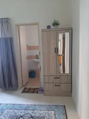a bathroom with a wooden cabinet and a mirror at MK Homestay Sunway in Ipoh