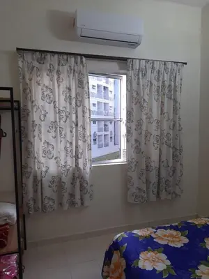 a bedroom with a bed and a window with curtains at MK Homestay Sunway in Ipoh