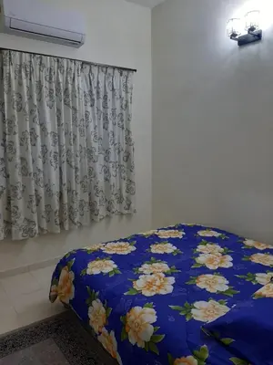 a bedroom with a blue bed with flowers on it at MK Homestay Sunway in Ipoh