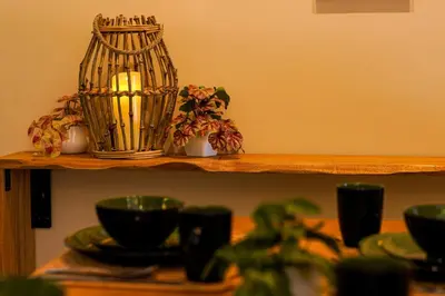 a shelf with a candle and some plates and bowls at Horizon Ipoh 8Pax 3R2B - Tropical Bird's Retreat in Ipoh