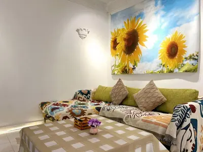 a living room with a couch and a painting of sunflowers at Vintage Comfort 3Bedroom Haus in Lunas