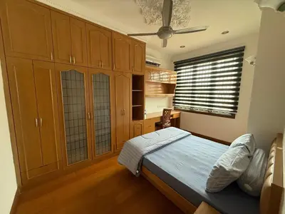 a bedroom with a bed and wooden cabinets and a window at Majestic Bungalow Seberang Jaya in Perai