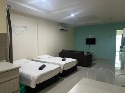 a hotel room with two beds and a couch at Homestay Marina in Lumut