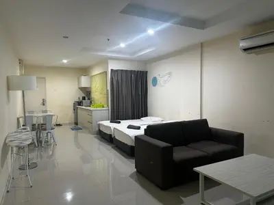 a room with a bed and a couch and a table at Homestay Marina in Lumut