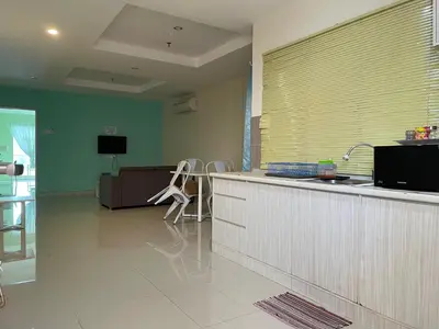 a kitchen with a sink and a counter with chairs at Homestay Marina in Lumut