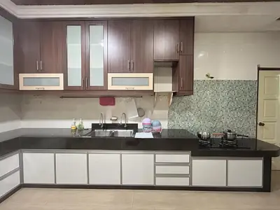 a kitchen with white cabinets and a black counter top at Life Art Home Family Ipoh Homestay 5R4B 18pax SY28 in Ipoh