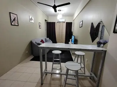 a kitchen with a table and stools in a room at Firza Suite in Gua Sai