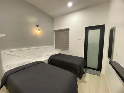 a bedroom with two beds and a mirror at 38G Homestay in Teluk Intan