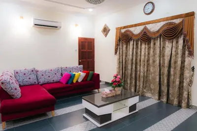 a living room with a red couch and a table at Villa Cinta Jasmeen in Kuala Kangsar