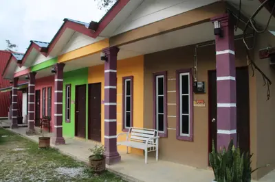 a row of colorful houses with a bench outside at Capital O 91187 D'dusun Raudhah Chalet in Baling