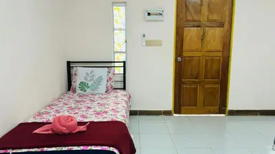 a bedroom with a bed with a pink towel on it at Capital O 91187 D'dusun Raudhah Chalet in Baling