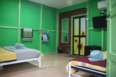 a green room with two beds and a mirror at Capital O 91187 D'dusun Raudhah Chalet in Baling